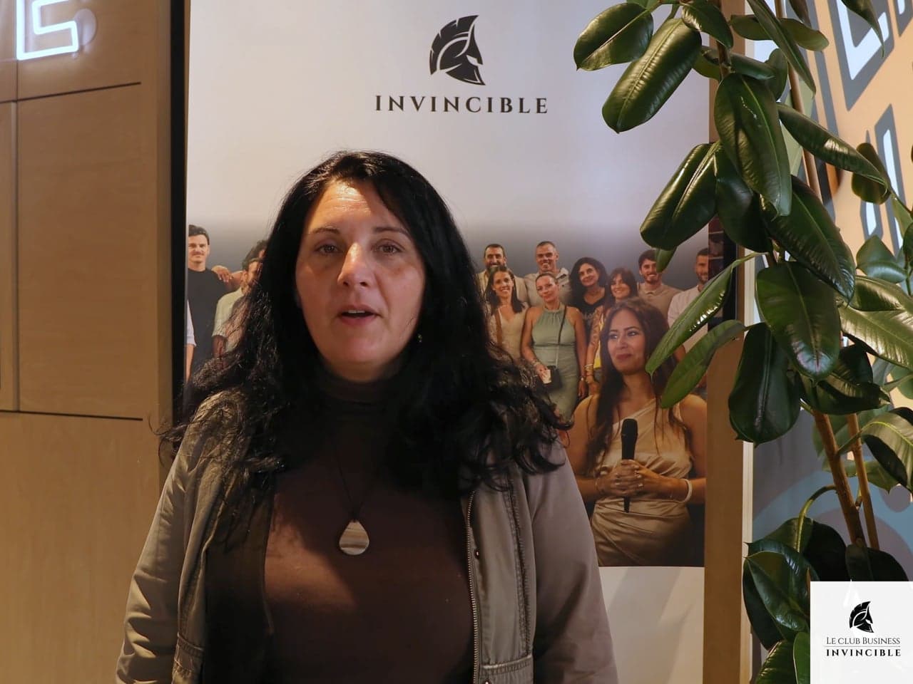 Alexandra, membre du Club Business Invincible, face caméra devant le kakémono du club